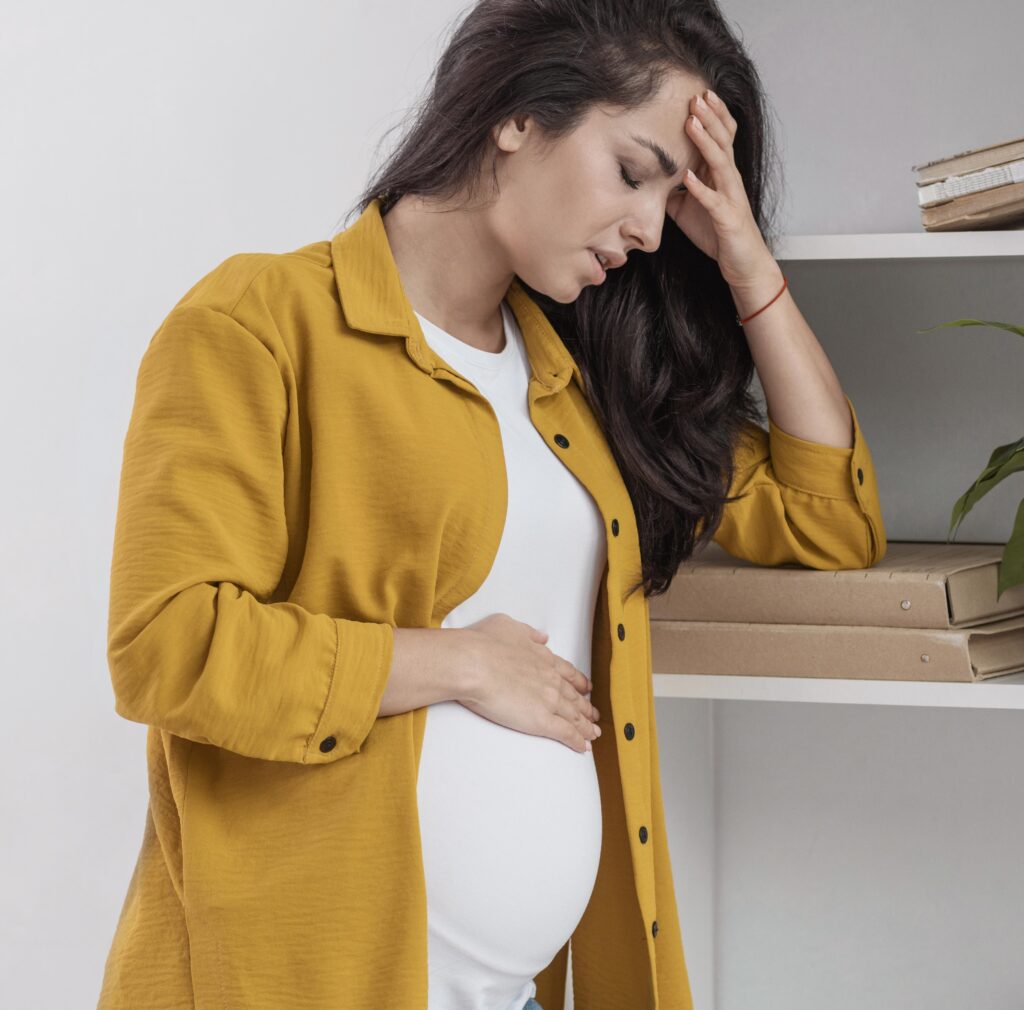 Pregnant woman appearing stressed, illustrating the challenges of managing stress during pregnancy, a key topic covered in our blog with helpful tips for maintaining emotional and physical well-being.